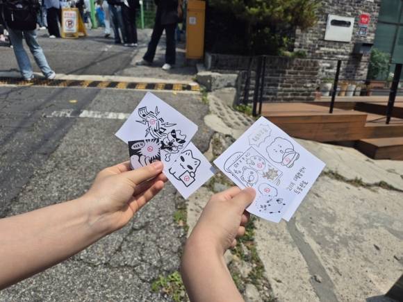 사전투표 첫날인 지난 29일 서울 서대문구 신촌역 인근 사전투표소에서 유권자들이 기표 도장을 찍은 종이를 들고 기념 촬영을 하는 모습. 송현주 기자