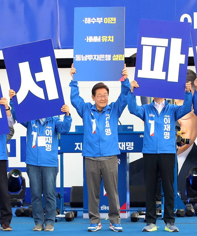 이재명 더불어민주당 대통령 후보가 1일 오후 부산 동구 부산역 광장에서 열린 유세에서 해수부 이전, HMM 유치, 동남투자은행 설립이 적힌 피켓을 들고 있다./뉴스1