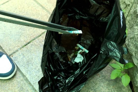 서울 성동구청 직원이 청사 주변에 버려져 있는 담배꽁초를 치우고 있다. 사진 성동구