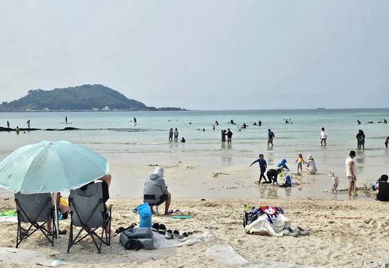 지난달 31일 오후 제주시 협재해수욕장을 찾은 피서객들이 물놀이를 즐기고 있다. 연합뉴스