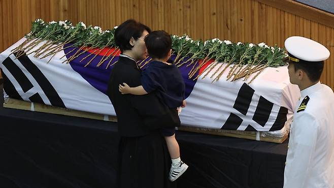 1일 경북 포항시 해군 항공사령부 강당에서 엄수된 '해군 P-3CK 917호기 순직자 영결식'에서 순직 해군 장병의 어린 아들이 헌화하며 마지막 배웅을 하고 있다. 사진=연합뉴스