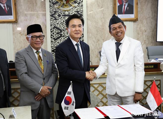 김태흠 충남지사가 지난 26일 동남아 핵심 국가인 인도네시아의 ‘경제수도’로 꼽히는 서자바주 데디 물야디와 주지사와 ‘교류 및 탄소중립 실현을 위한 공동선언’을 채택한 뒤 두 손을 굳게 잡고 있다.