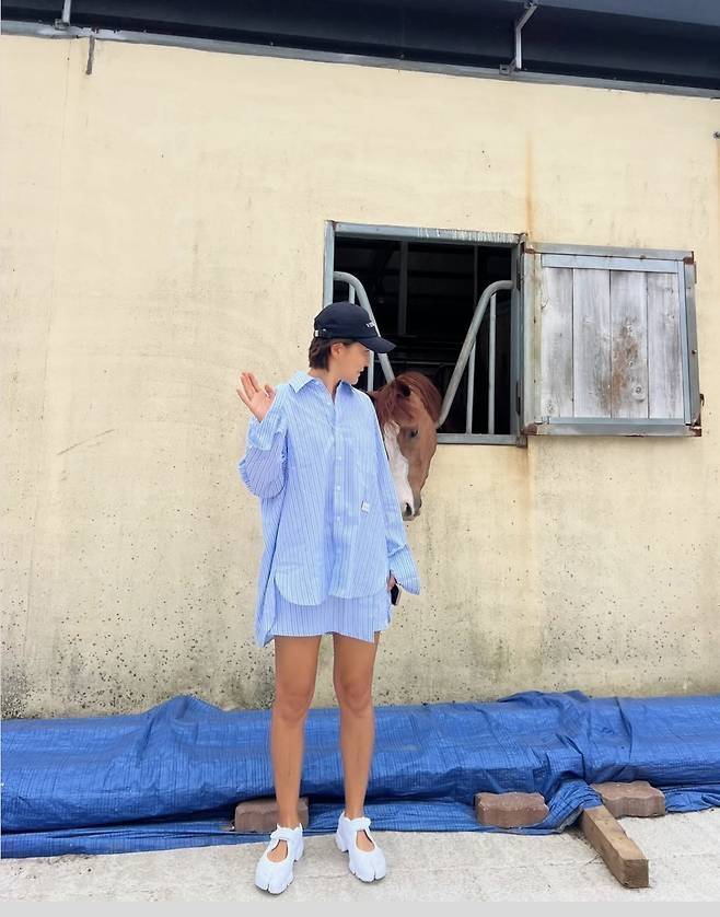 볼캡과 독특한 디자인의 화이트 스니커즈로 경쾌한 리듬감을 더하며, 마치 목장 위를 걷는 런웨이 모델 같은 포스를 자아냈다.사진=진서연 SNS