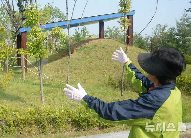 [전주=뉴시스] 김얼 기자 = 전북 전주시 덕진구 만성동에 위치한 문화공원을 찾은 한 시민이 나무에 생긴 상처를 설명하고 있다. 2025.06.01. pmkeul@newsis.com