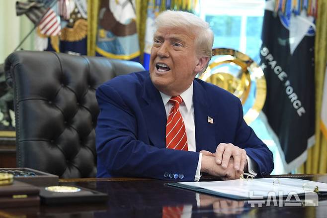 [워싱턴=AP/뉴시스]도널드 트럼프 미국 대통령이 30일(현지 시간) 백악관 집무실에서 일론 머스크 테슬라 최고경영자(CEO)를 배석한 채 기자들의 질문에 답하고 있다. 2025.05.31.