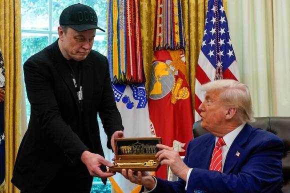 지난달 30일(현지시간) 미국 워싱턴DC 백악관 오벌오피스에서 도널드 트럼프(오른쪽) 대통령이 정부효율부(DOGE) 수장에서 물러나는 일론 머스크 테슬라 최고경영자(CEO)에게 ‘황금 열쇠’를 선물하고 있다. 워싱턴DC 로이터 연합뉴스