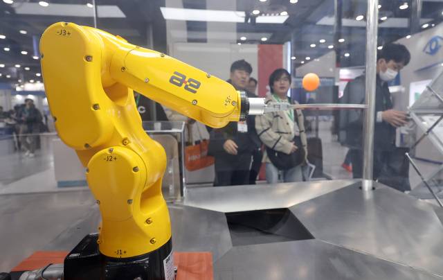 관람객들이 올해 3월 서울 강남구 코엑스에서 열린 2025 스마트공장·자동화산업전에서 탁구공을 튀기는 다관절 로봇을 살펴보고 있다. 뉴스1