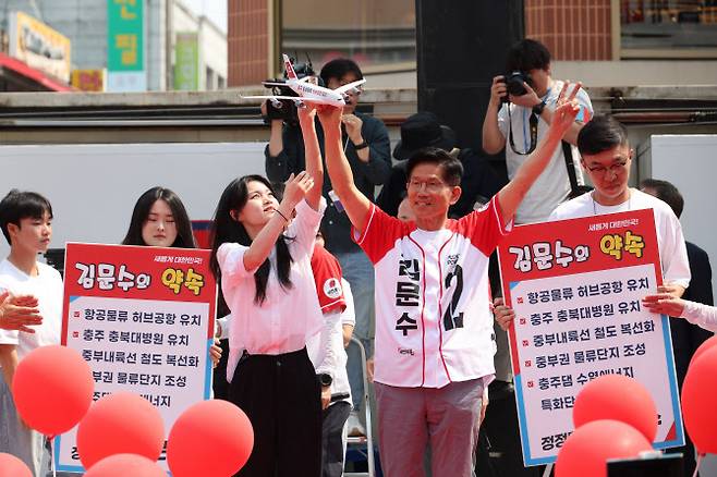 김문수 국민의힘 대선 후보가 30일 충북 충주시 젊음의 거리에서 열린 유세에서 ‘충주 항공물류 허브공항 유치’ 라고 적힌 비행기 모형을 받고 있다.(사진=연합뉴스)
