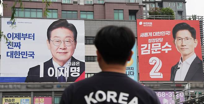 Large campaign banners for Democratic Party of Korea candidate Lee Jae-myung and People Power Party candidate Kim Moon-soo hang on a building in Uiwang, Gyeonggi Province, on June 2, 2025, a day before South Korea’s 21st presidential election./Yonhap