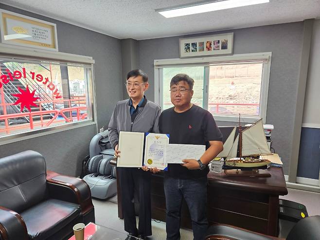 2일 오후 정근호 안동경찰서장이 안동시 성곡동 안동댐 선착장 인근 사무실에서 백민규(오른쪽)씨에게 미제 실종사건을 해결한 공로로 감사장과 부상을 전달했다. /권광순 기자