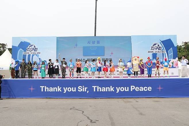 ▲ ‘2025 지구런 : 더 피스 로드’ 베스트 피스 드레서 참가자들이 평화를 주제로 한 다양한 개성 넘치는 복장으로 무대에 올라 시상식에 참여하고 있다. (사진제공=지구런)
