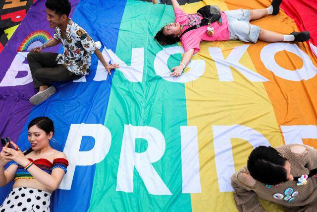 1일 태국 방콕에서 열린 성소수자 퍼레이드에서 시민과 관광객들이 성소수자를 상징하는 6색 무지개 현수막 위에서 포즈를 취하고 있다. 방콕=로이터 연합뉴스