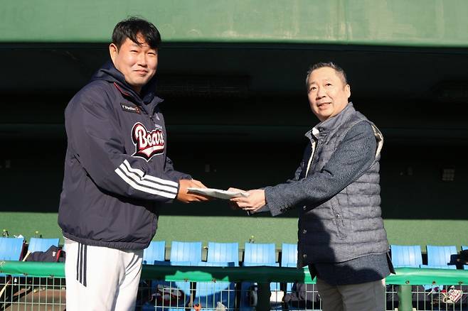 지난 2월 일본 미야자카 스프링캠프를 방문한 박정원 구단주가 양의지에게 격려금을 전달하고 있다. 두산 제공