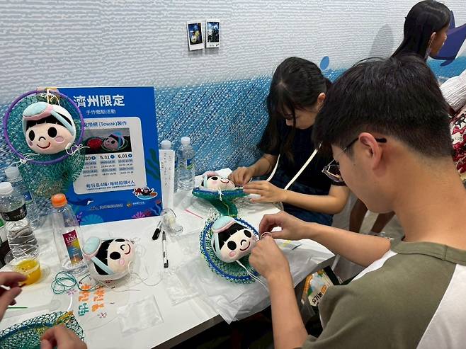 ‘태왁 만들기’ 체험 부스에 참여한 대만 가족 단위 관람객들이 제주 해녀 문화를 손으로 직접 배우며 즐거운 시간을 보내고 있다. (제주관광공사 제공)