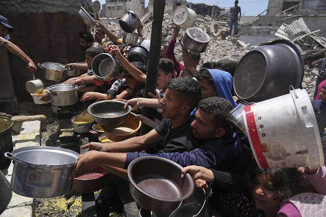 5월19일(현지 시간) 가자지구 북부 자발리아의 급식소에 구호 음식을 받으려는 팔레스타인 주민들이 몰려들고 있다. 이스라엘은 지난 10주간 가자지구 내 구호물자 반입을 전면 차단해 왔던 봉쇄를 완화하고 기본 식량 반입을 허용하기로 했다. /AP 뉴시스