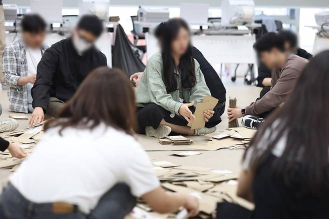 제21대 대통령선거 사전투표 둘째 날인 30일 서울 중구 을지누리센터에 마련된 사전투표소에서 사전투표사무원들이 참관인 및 공정선거참관단이 지켜보는 가운데 관외투표함을 열어 투표용지 분류 작업을 하고 있다. /사진=연합뉴스