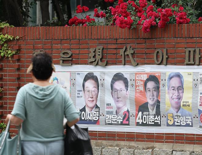 21대 대선을 하루 앞둔 2일 시민이 서울의 한 아파트에 붙은 대선 후보 벽보 옆을 지나가고 있다. 연합뉴스