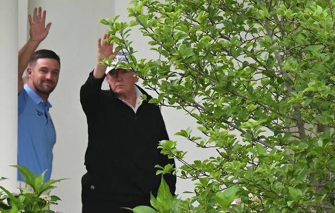 도널드 트럼프 미국 대통령이 1일(현지시간) 프로 골프 선수 브라이슨 디솀보와 함께 워싱턴DC에서 골프 라운딩을 마친 뒤 백악관 집무실로 향하며 손을 흔들고 있다. 연합뉴스