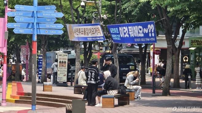 29일 서울 홍대입구역 인근. 사전투표를 독려하는 현수막 아래 청년들이 휴식을 취하고 있다./사진=박상곤 기자