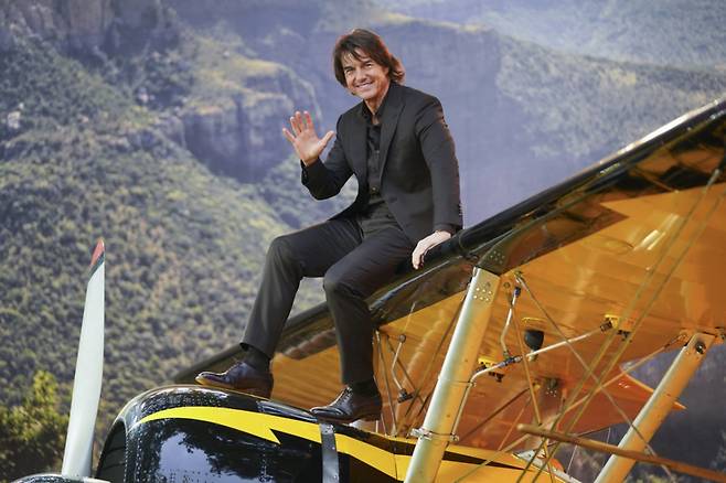 [런던=AP/뉴시스] 배우 톰 크루즈가 15일(현지 시간) 영국 런던에서 열린 영화 '미션 임파서블: 파이널 레코닝' 시사회에 참석해 비행기 세트 위에 올라가 포즈를 취하고 있다. 2025.05.16.