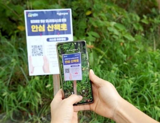 한 주민이 성동구 ‘산책로 범죄예방시스템’을 이용하는 모습. 성동구 제공