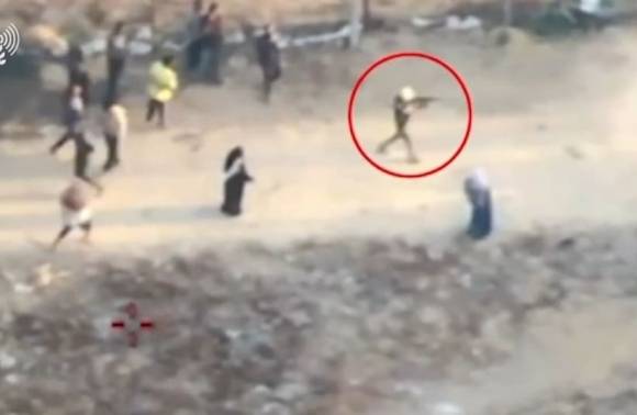 1일(현지시간) 가자지구 남부 칸유니스에서 머리에 천을 뒤집어써 얼굴을 가리고 소총을 든 무장 괴한들이 배급소 주변 주민들에게 총을 쏘고 돌을 집어 던지고 있다. 출처=이스라엘군 대변인실