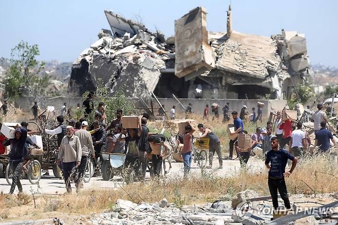 지난 29일(현지시간) GHF 배급소에서 구호품 받아 가는 가자지구 주민들. [AFP 연합뉴스 자료사진. 재판매 및 DB 금지]