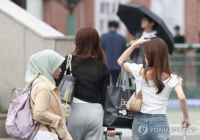 '손으로 비 막으며' (서울=연합뉴스) 김성민 기자 = 소나기가 내린 2일 서울 서울역 인근에서 시민들이 이동하고 있다. 2025.6.2 ksm7976@yna.co.kr
