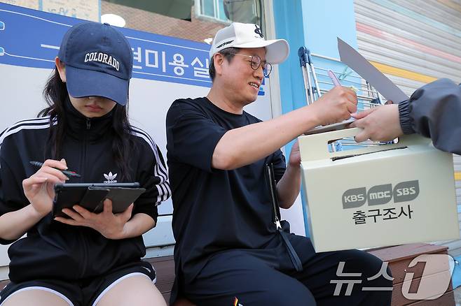 제21대 대통령선거 본투표가 시작된 3일 오후 서울 성동구 금호2·3가동제1투표장 인근에서 투표를 마친 부녀 유권자가 KBS·MBC·SBS 지상파 방송3사 출구조사에 응하고 있다. 2025.6.3/뉴스1 ⓒ News1 박정호 기자