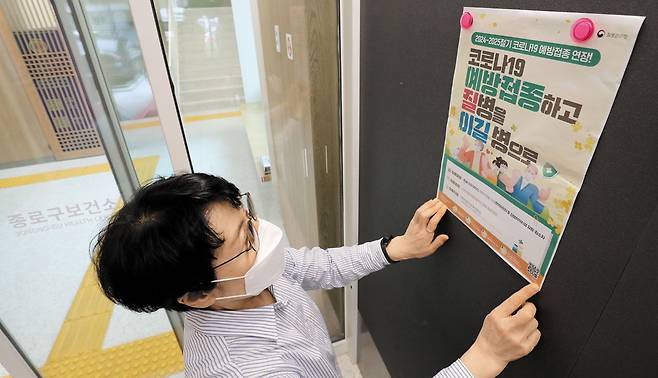 고위험군 코로나 예방접종기간 30일까지 연장 - 2일 서울 옥인동 종로구 보건소에서 직원이 65세 이상 등 고위험군이 대상인 무료 코로나19 예방접종 기간이 30일까지로 연장됐다는 내용의 안내 포스터를 붙이고 있다. /장경식 기자