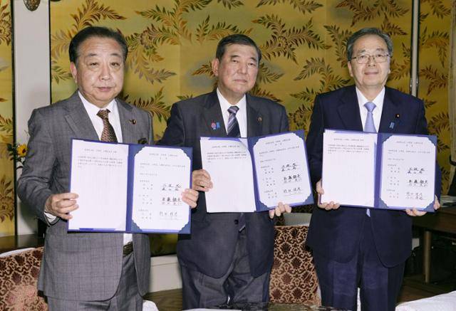 일본 집권 자민당 총재인 이시바 시게루(가운데) 총리와 연립여당 공명당의 사이토 데쓰오(오른쪽) 대표, 제1야당 입헌민주당의 노다 요시히코 대표가 지난달 27일 연금 제도 개편에 합의한 뒤 서명한 문서를 들어 보이고 있다. 도쿄=교도 연합뉴스