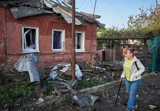 2일 우크라이나 하르키우에서 한 여성이 밤새 연합 공격을 받아 파손된 집을 지나가고 있다. 하르키우=EPA 연합뉴스