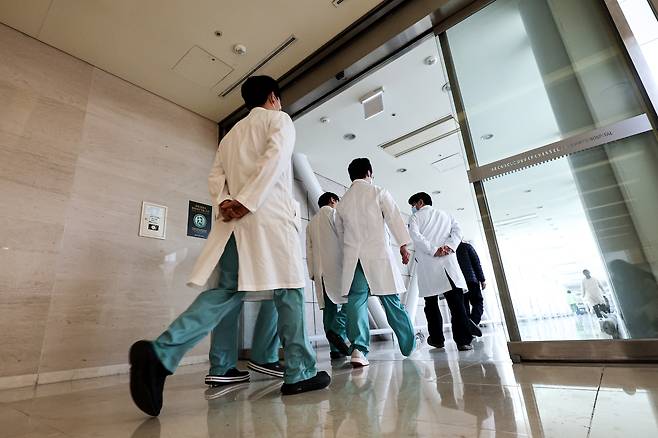 Doctors walk inside a general hospital in Seoul on Feb. 8, two days after the government announced its plan to add 2,000 new seats in medical schools' admissions. [YONHAP]