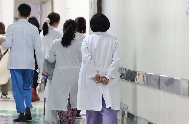 Medical staff walk inside Seoul National University Hospital in Jongno District, central Seoul on Feb. 25. [YONHAP]
