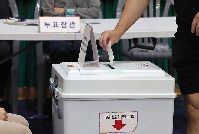 제21대 대통령선거 투표일인 3일 오후 울산 남구 월평초등학교 체육관에 설치된 신정4동 제2투표소에서 투표참관인들이 지켜보는 가운데 한 유권자가 기표를 마친 투표지를 투표함에 넣고 있다. 연합뉴스
