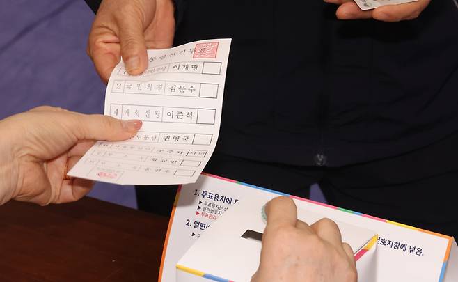 제21대 대통령 선거일인 3일 오전 제주도 제주시 제주도의회 의원회관 연동 제1투표소에서 한 유권자가 투표용지를 배부받고 있다. [사진 = 연합뉴스]
