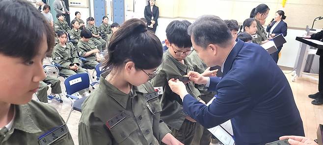 이동신 울릉교육장이  어린이 독도의용수비대원에게 명찰을 붙여주고 있다[울릉교육지원청 제공]
