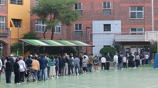 21대 대통령 선거일인 3일 새벽 서울 서초구 원명초등학교에 마련된 서초4동제3투표소를 찾은 유권자들이 투표하기 위해 줄을 서고 있다.