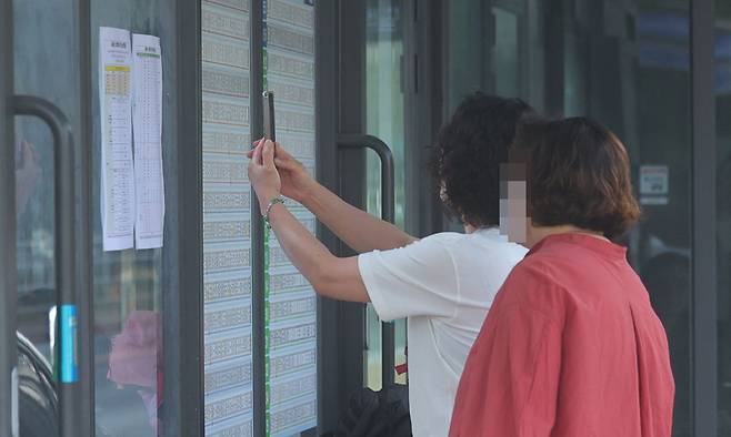 경남 창원지역 시내버스가 파업에 돌입한 지난 5월 28일 창원 성산구 시민생활체육관 정류장에서 시민들이 임시 버스 시간표를 들여다보고 있다. 연합뉴스