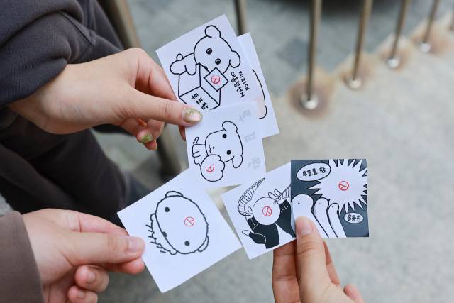 서울 관악구 낙성대동주민센터에서 투표를 마친 유권자들이 인증 용지를 들어보이고 있다. 연합뉴스