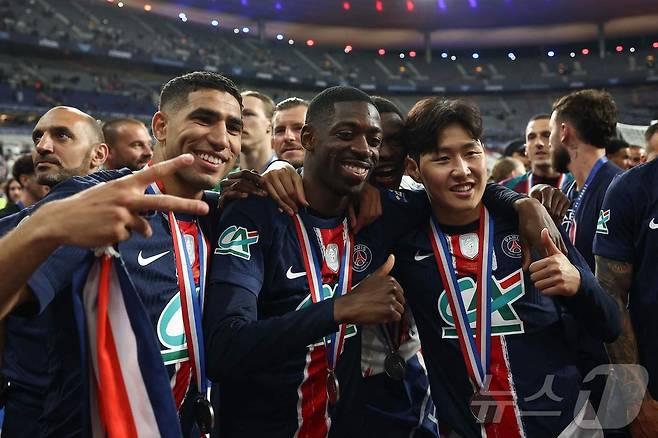 PSG 이강인이 지난달 25일 쿠프 드 프랑스 결승에서 승리 후 팀 동료 아슈라프 하키미, 우스만 뎀벨레와 함께 포즈를 취하며 기뻐하고 있다. AFP연합뉴스