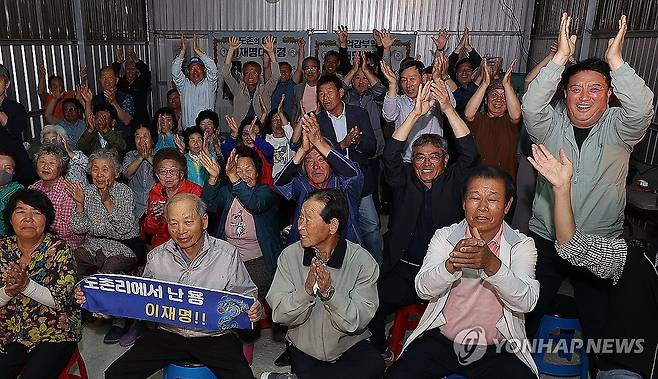 '도촌리에서 용났네'…환호하는 이재명 후보 고향 주민들 (안동=연합뉴스) 윤관식 기자 = 3일 더불어민주당 이재명 대선 후보의 고향인 경북 안동시 예안면 도촌리의 경로당 창고에서 마을 주민들이 제21대 대통령 선거 출구조사 결과를 확인하고 환호하고 있다. 2025.6.3 psik@yna.co.kr