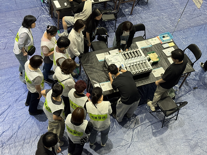 3일 오후 7시 30분쯤 대구 북구 경북대학교 대구캠퍼스체육진흥센터 내 개표소에서 선관위 측이 분류기기의 봉인지를 해제하는 장면을 참관인이 살피고 있다. 박영민기자.