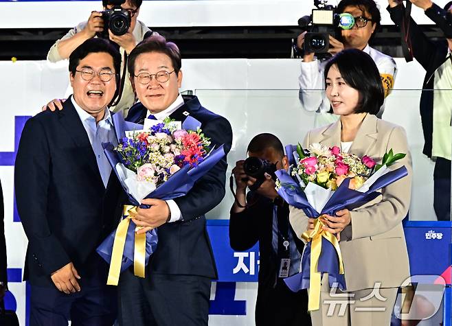 당선이 확실시된 이재명 더불어민주당 대통령 후보가 김혜경 여사와 4일 오전 서울 여의도 국회 앞을 찾아 박찬대 상임총괄선대본부장으로부터 꽃다발을 받고 있다. (공동취재) 2025.6.4/뉴스1 ⓒ News1 안은나 기자