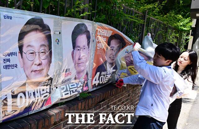 제21대 대통령선거 다음 날인 4일 오후 서울시선관위 관계자들이 서울 종로구 예술가의 집 담장에 부착된 선거벽보를 철거하고 있다. /이새롬 기자