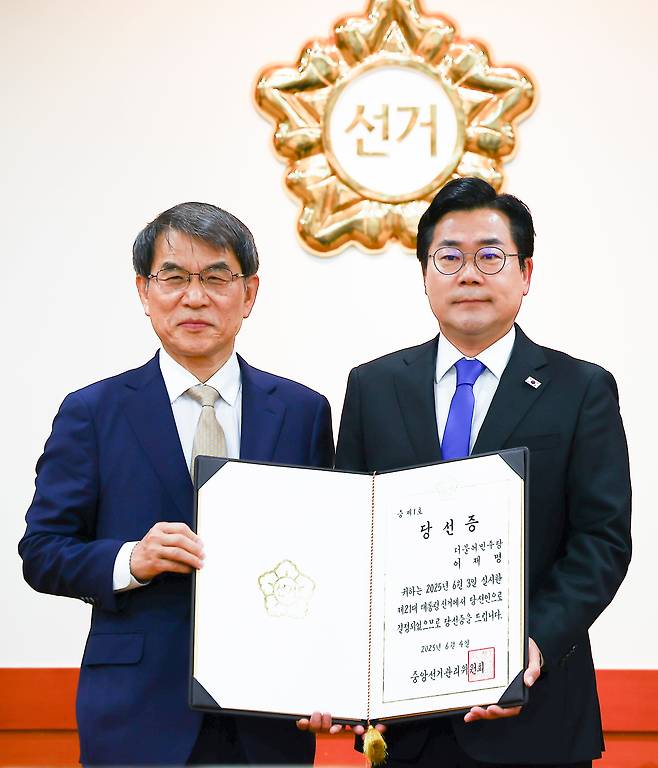 노태악(왼쪽) 중앙선거관리위원장이 4일 오전 경기 과천시 중앙선거관리위원회 회의실에서 열린 제21대 대통령 당선증 교부식에서 박찬대 더불어민주당 상임 총괄선거대책위원장에게 당선증을 전달하고 기념촬영을 하고 있다./뉴시스