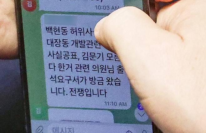 이재명 더불어민주당 대표가 지난 2022년 9월 국회 본회의에서 김현지 보좌관(전 경기도청 비서관)에게 "백현동 허위사실공표, 대장동 개발관련 허위사실공표, 김문기 모른다 한 거 관련 의원님 출석요구서가 방금 왔습니다. 전쟁입니다"라는 문자를 받고 있다. /뉴스1