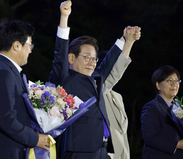 이재명 더불어민주당 후보가 제21대 대통령 당선이 확실시된 4일 오전 1시20분께 서울 여의도 국회 인근에서 당 주최로 열린 국민개표방송 행사에 참석해 김혜경 여사와 함께 시민들을 향해 두 팔을 들어 인사하고 있다. 공동취재사진