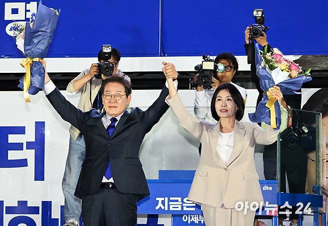 제21대 대통령 당선이 확실시 되는 이재명 더불어민주당 대선 후보가 4일 서울 여의도 국회 정문 앞에 마련된 개표방송 야외무대에서 김혜경 여사와 함께 인사를 하고 있다. [사진=곽영래 기자]