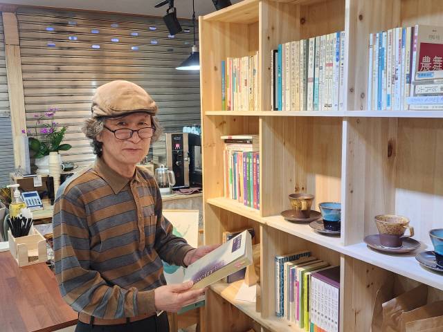 ▲ 정주신 시인이 가장 좋아하는 이승훈 시인의 저서 ‘선과 하이데거’를 펼쳐 보이고 있다.